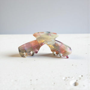 Aura pastel blend hat claw clip displayed on a tabletop, showcasing its soft multicolor finish and everyday style.