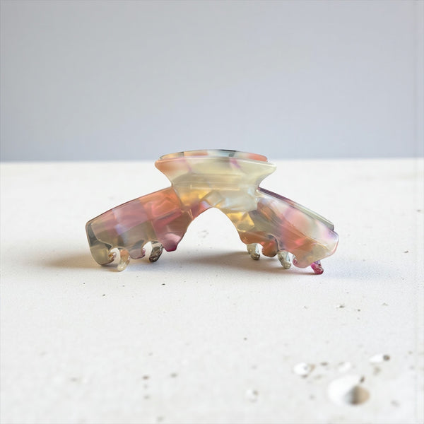 Aura pastel blend hat claw clip displayed on a tabletop, showcasing its soft multicolor finish and everyday style.