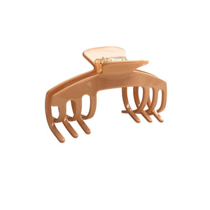 Angled view of the Biscotti warm beige hat claw clip showing its curved shape, soft neutral finish, and secure grip.