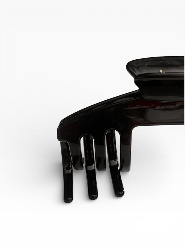 Close-up of the Eclipse glossy black hat claw clip highlighting the smooth finish, curved teeth, and low-profile shape.