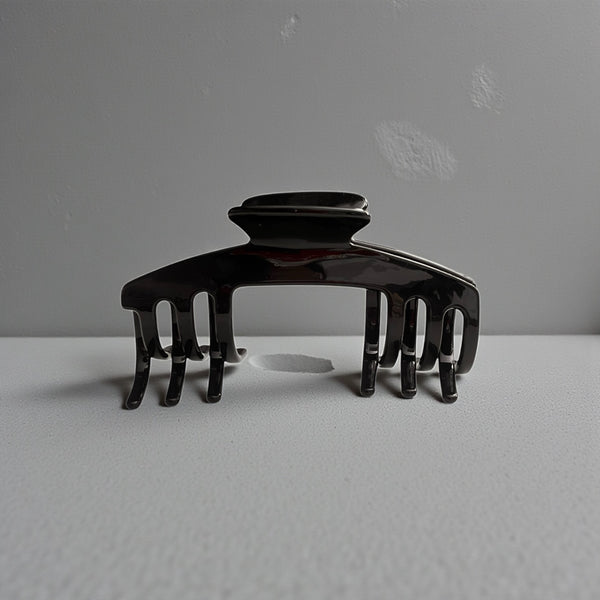 Eclipse glossy black hat claw clip displayed on a neutral surface, highlighting its sleek finish and everyday style.