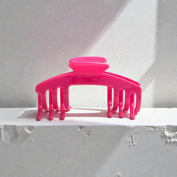 Flamingo hot pink hat claw clip displayed on a light surface, highlighting its bold color and everyday hat-friendly design.