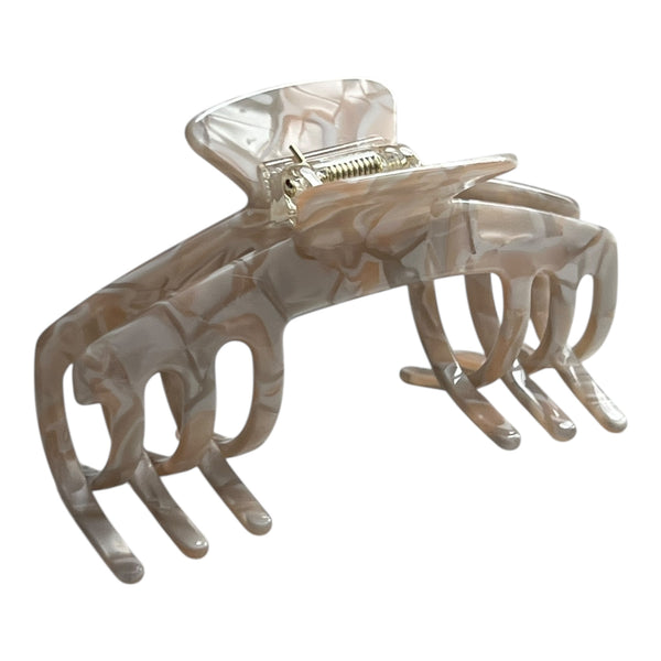 Angled view of the Halo pearl beige hat claw clip showing its curved shape, soft neutral finish, and secure grip.
