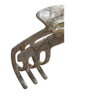Close-up of the Halo pearl beige hat claw clip highlighting the glossy finish, spring hinge, and smooth curved teeth.