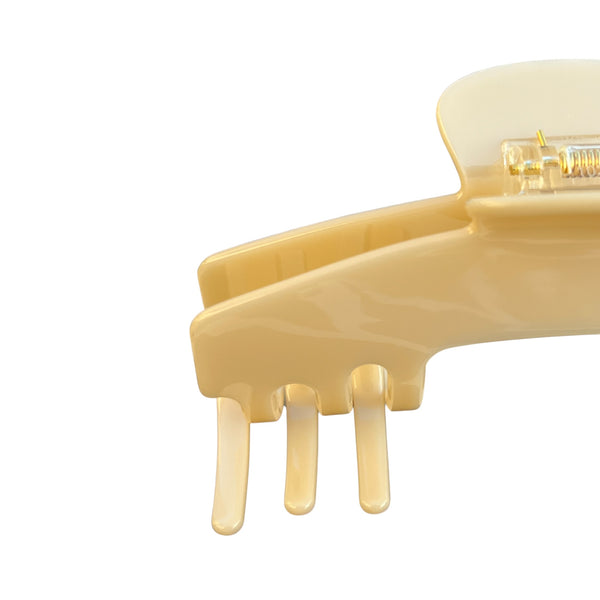 Close-up of the Ivory cream hat claw clip highlighting the smooth finish, spring hinge, and curved grip teeth.