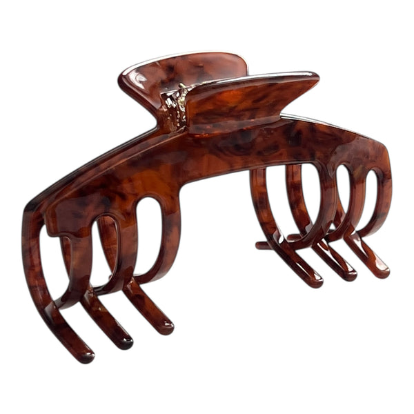 Angled view of the Mocha brown tortoise hat claw clip showing its curved shape, warm pattern, and secure grip.