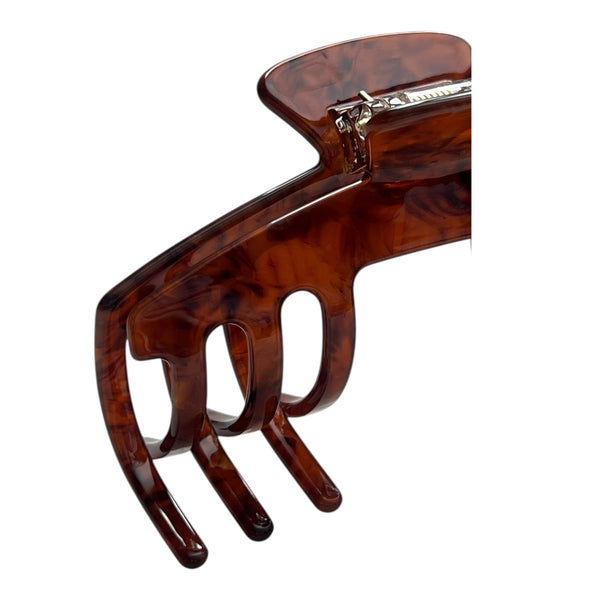 Close-up of the Mocha brown tortoise hat claw clip highlighting the glossy finish, spring hinge, and curved grip teeth.