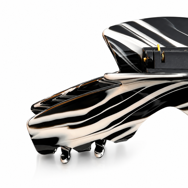 Close-up of the Noir black and white swirl hat claw clip highlighting the glossy finish, spring hinge, and smooth grip teeth.