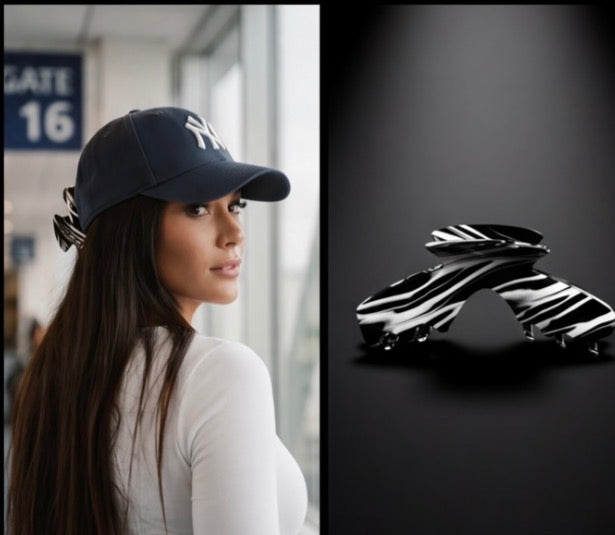 A woman wearing a navy baseball cap with a white New York Yankees logo is shown in profile, alongside a separate product shot of Noir hair claw for hat from Baddie Clip.