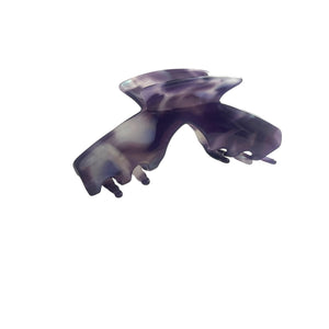Angled view of the Nova purple marble hat claw clip showing its curved shape and secure grip for everyday hairstyles.