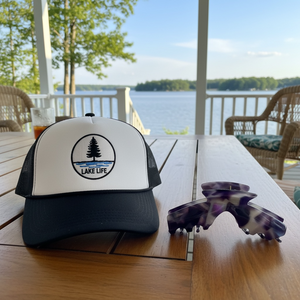 Nova purple marble hat claw clip displayed beside a trucker hat by the lake, designed for comfortable hairstyles while wearing hats.