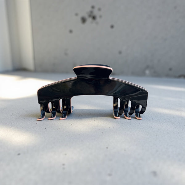Onyx black hat claw clip displayed on a clean surface, highlighting its sleek finish and everyday Power Hold design.