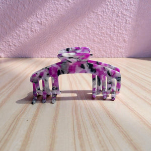 Orchid purple marble hat claw clip displayed on a wooden surface, highlighting its bold multicolor finish and everyday style.