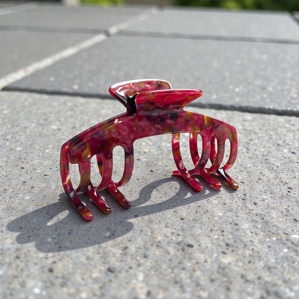 Ruby red mosaic hat claw clip displayed outdoors, highlighting its bold color and everyday hat-friendly design.