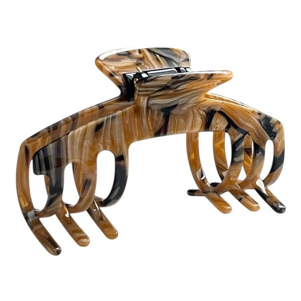 Angled view of the Tortoise brown marble hat claw clip showing its curved shape, classic pattern, and secure grip.