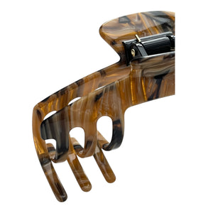 Close-up of the Tortoise brown marble hat claw clip highlighting the glossy finish, spring hinge, and curved grip teeth.